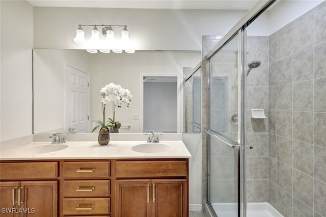 full bathroom with double vanity, a sink, and a shower stall