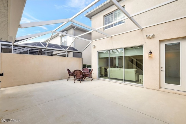 view of patio featuring glass enclosure