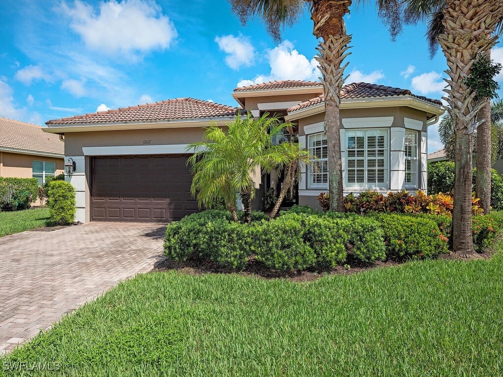 mediterranean / spanish-style house featuring a front lawn and a garage