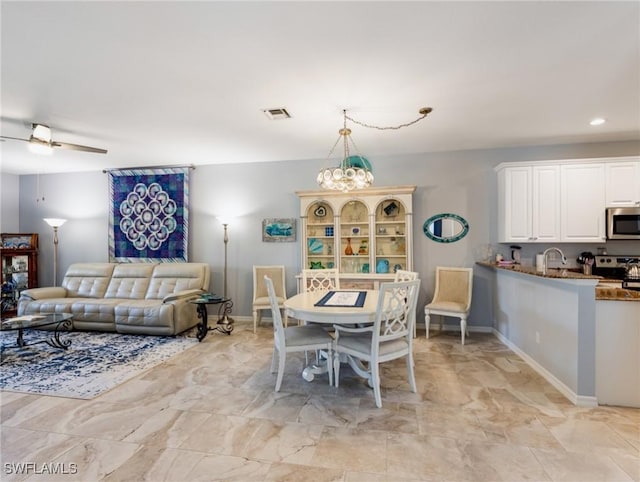 dining area featuring sink and a chandelier