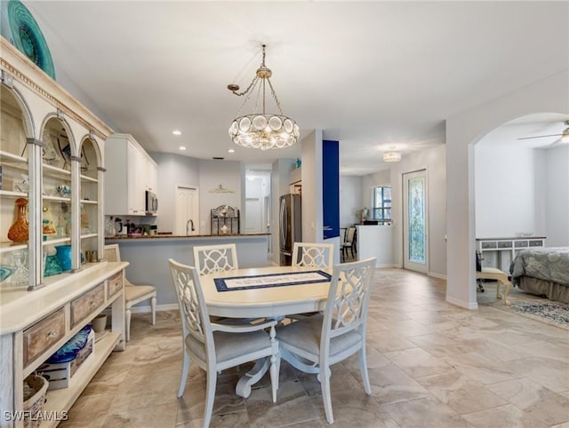 dining room with ceiling fan with notable chandelier