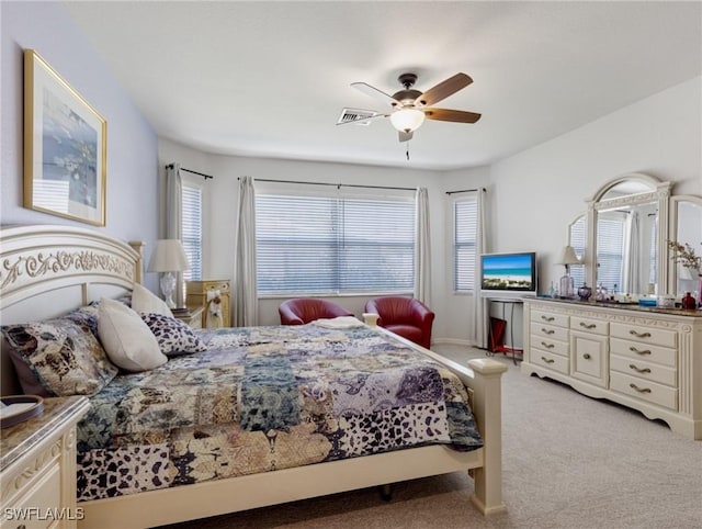 carpeted bedroom with ceiling fan and multiple windows