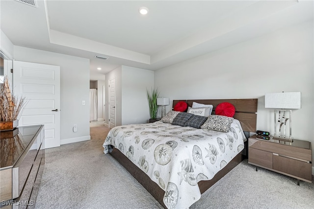 carpeted bedroom featuring a tray ceiling