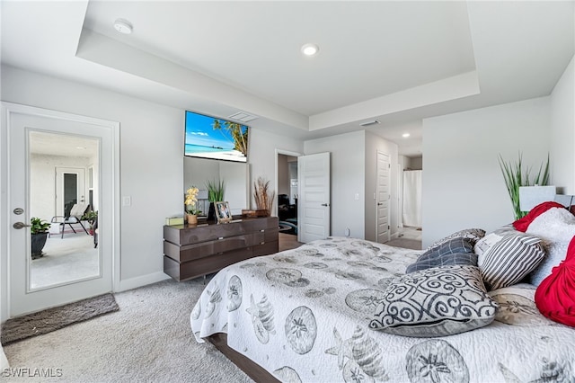 carpeted bedroom with a tray ceiling