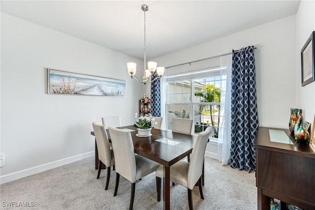 dining space featuring light colored carpet and an inviting chandelier