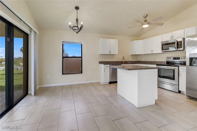 kitchen with a center island, white cabinets, stainless steel appliances, and decorative light fixtures