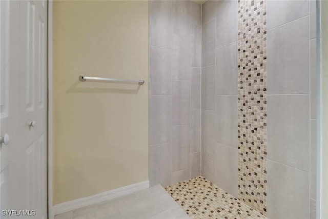 bathroom featuring tile patterned flooring and a tile shower