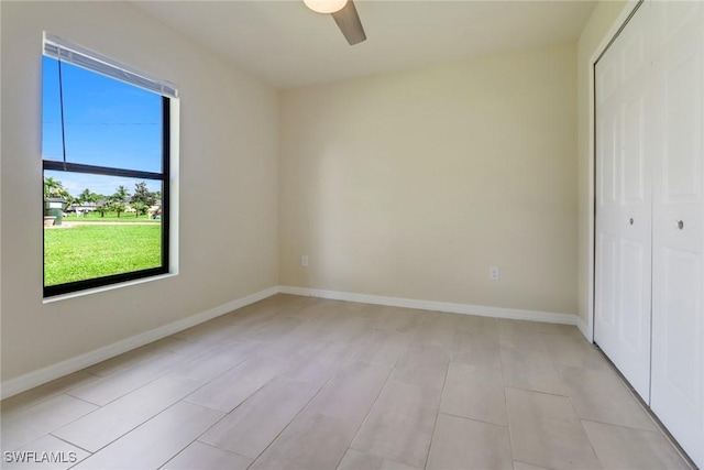 unfurnished bedroom featuring ceiling fan and a closet