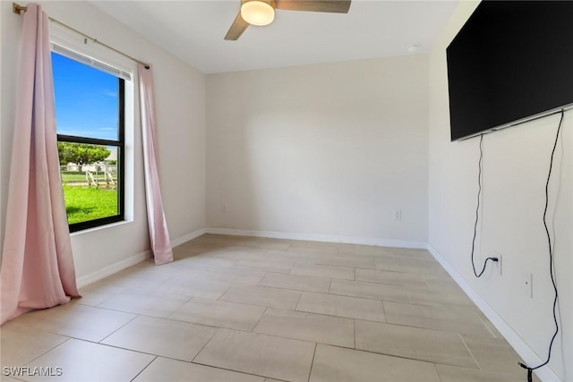 tiled empty room with a wealth of natural light and ceiling fan