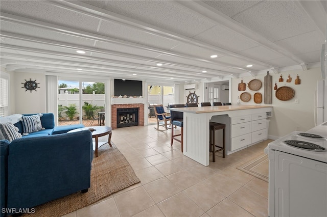 tiled living room with a wall unit AC and a brick fireplace