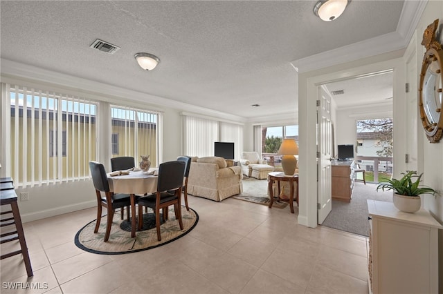 tiled dining space with a textured ceiling, a wealth of natural light, and ornamental molding