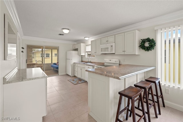 kitchen featuring a kitchen breakfast bar, kitchen peninsula, white appliances, light tile patterned floors, and ornamental molding