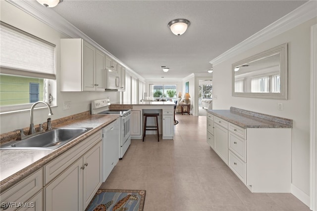 kitchen featuring white cabinets, white appliances, ornamental molding, and sink