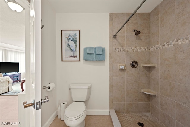 bathroom with tile patterned flooring, toilet, and tiled shower