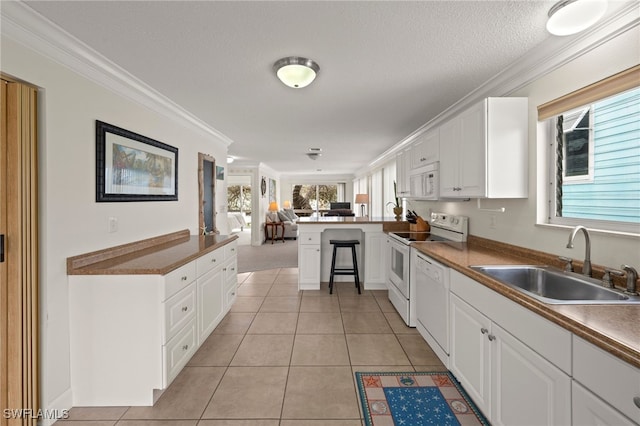 kitchen featuring white appliances, crown molding, kitchen peninsula, sink, and white cabinetry