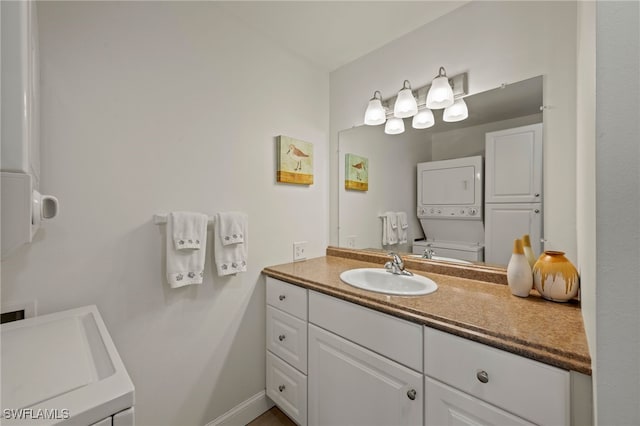 bathroom with vanity, toilet, and stacked washer and clothes dryer