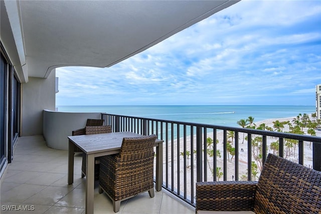 balcony with a water view and a view of the beach