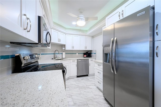 kitchen with appliances with stainless steel finishes, backsplash, white cabinets, and sink