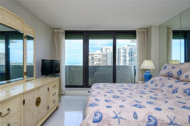 bedroom featuring access to outside, light tile patterned floors, and a wall of windows