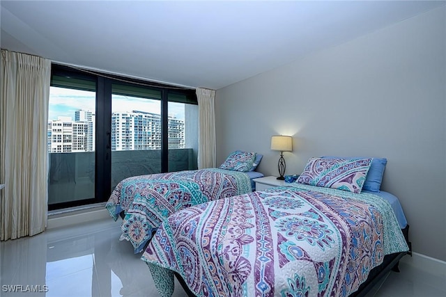 bedroom with access to exterior, a wall of windows, and tile patterned floors