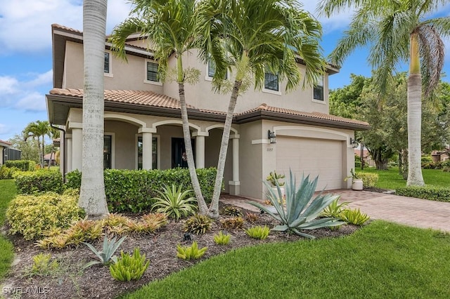 mediterranean / spanish-style home featuring a garage and a front yard