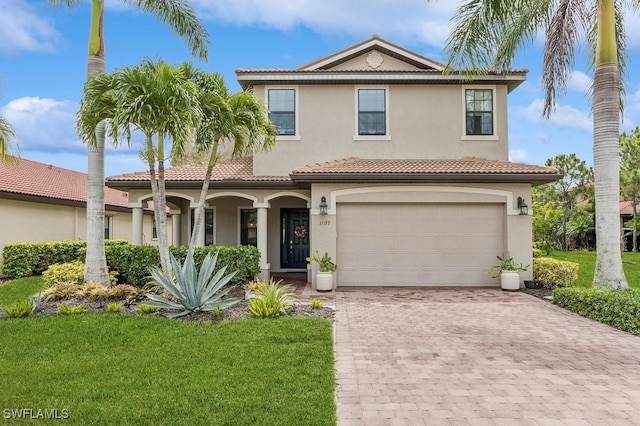 mediterranean / spanish-style house with a garage and a front lawn