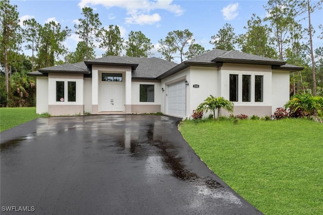 prairie-style home featuring a front yard and a garage