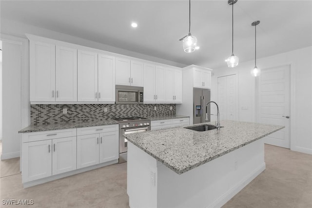 kitchen featuring white cabinets, premium appliances, sink, and decorative light fixtures