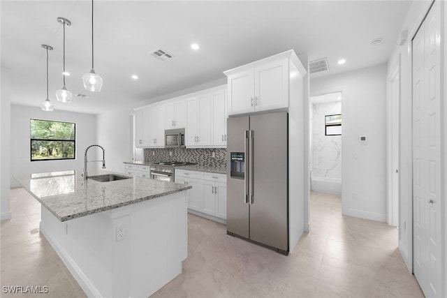 kitchen featuring a center island with sink, white cabinetry, sink, and appliances with stainless steel finishes