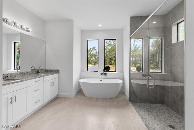 bathroom with tile patterned floors, vanity, shower with separate bathtub, and a wealth of natural light