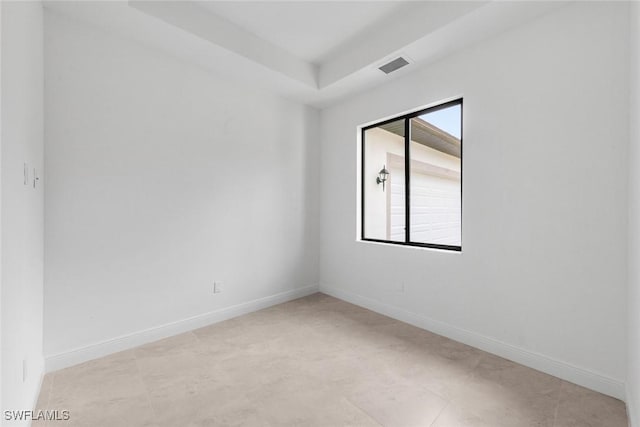 unfurnished room with a wealth of natural light and a tray ceiling