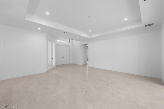 unfurnished room featuring a raised ceiling