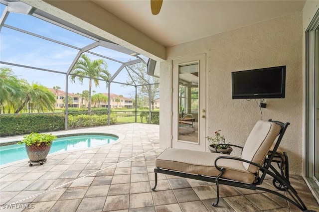 view of swimming pool with glass enclosure and a patio area