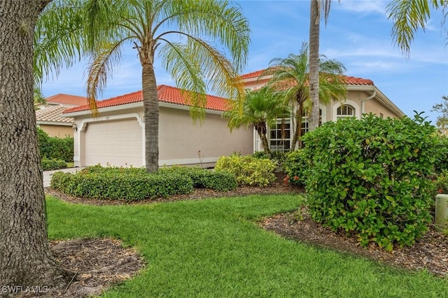 mediterranean / spanish home with a front lawn and a garage