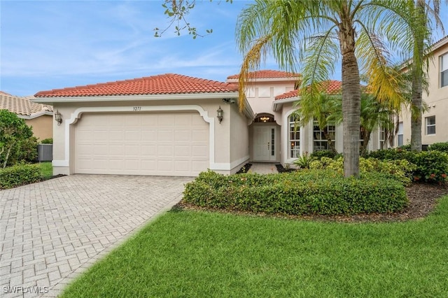 mediterranean / spanish house featuring central AC unit, a front yard, and a garage