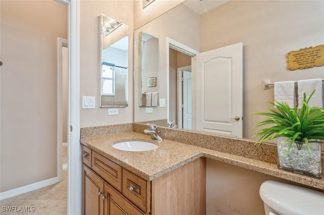 bathroom with tile patterned flooring, vanity, and toilet