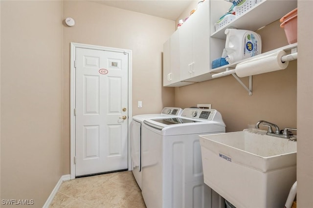 laundry area featuring cabinets, washer and clothes dryer, and sink