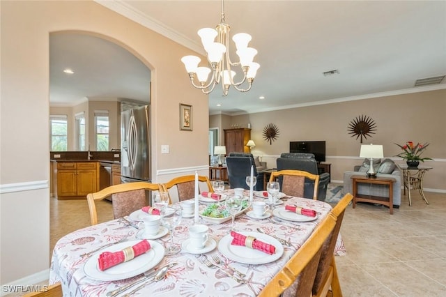 dining space with light tile patterned flooring, ornamental molding, sink, and an inviting chandelier