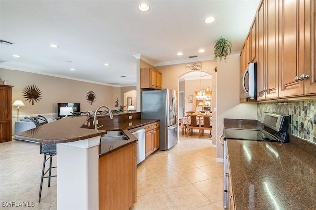 kitchen with sink, stainless steel appliances, tasteful backsplash, a breakfast bar area, and light tile patterned floors