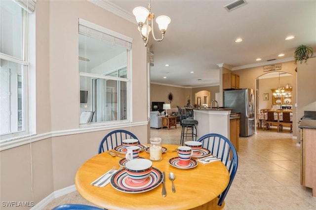 dining room with a healthy amount of sunlight, crown molding, and a chandelier