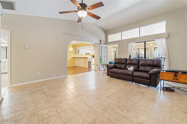 tiled living room featuring ceiling fan and vaulted ceiling