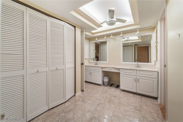 bathroom with vanity, a raised ceiling, and ceiling fan