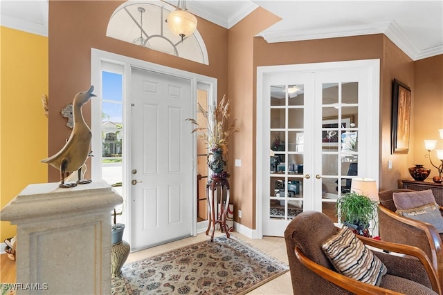 entrance foyer with light tile patterned floors, baseboards, crown molding, and french doors