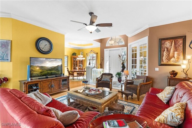 living area featuring a ceiling fan, ornamental molding, and wood finished floors