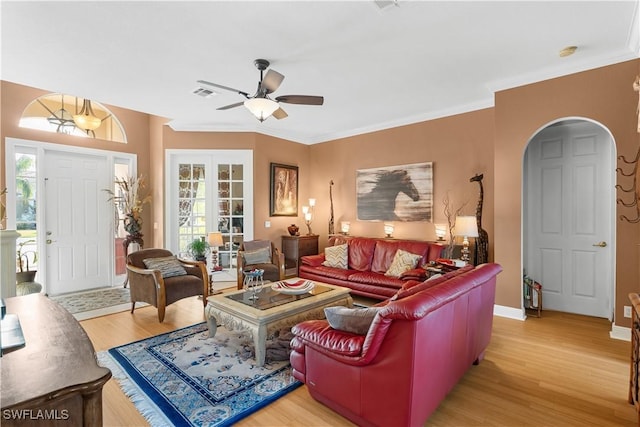 living room with ceiling fan, crown molding, and light wood-type flooring