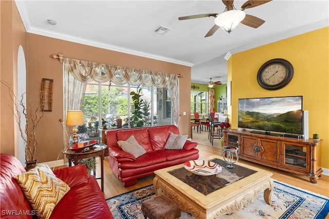 living room with light hardwood / wood-style flooring and crown molding