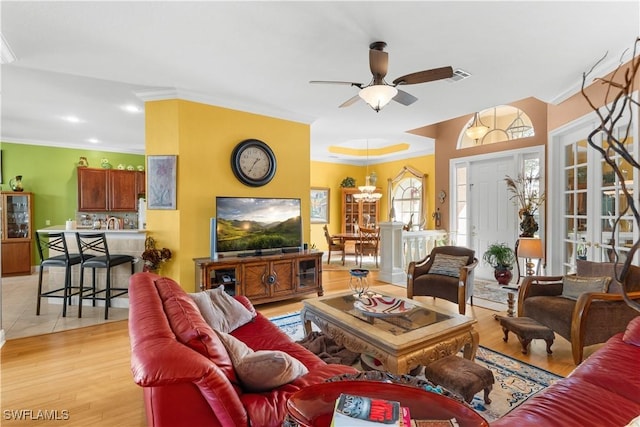 living room featuring ceiling fan, light hardwood / wood-style floors, and crown molding