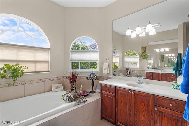 bathroom with tiled tub and vanity