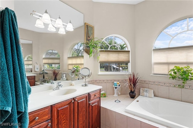 bathroom featuring vanity and tiled tub