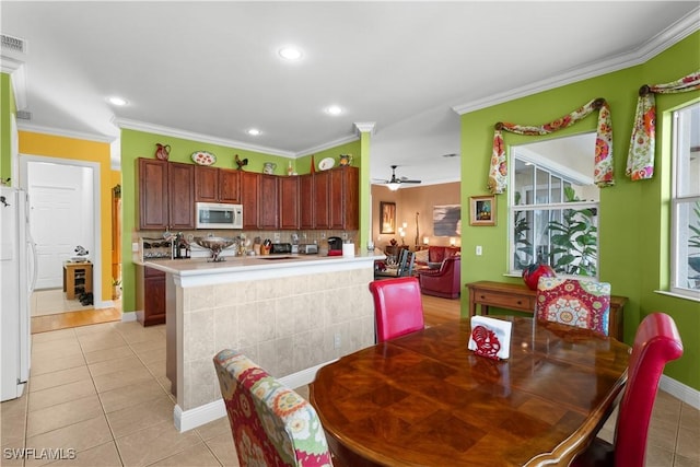 dining area with light tile patterned floors, ceiling fan, and crown molding